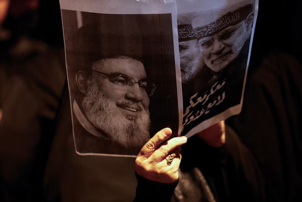 An Iraqi woman holds a picture of Lebanon's Hezbollah leader Sayyed Hassan Nasrallah as she attends protest following the announcement of his death, in Baghdad, Iraq, September 28, 2024.