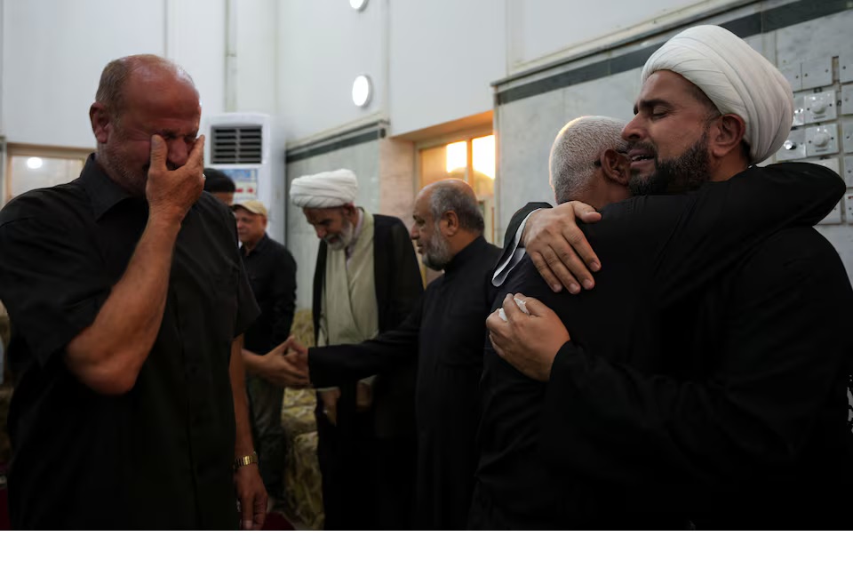 People react as they attend a gathering to offer condolences following the announcement of the death of Lebanon's Hezbollah leader Sayyed Hassan Nasrallah, in Basra, Iraq